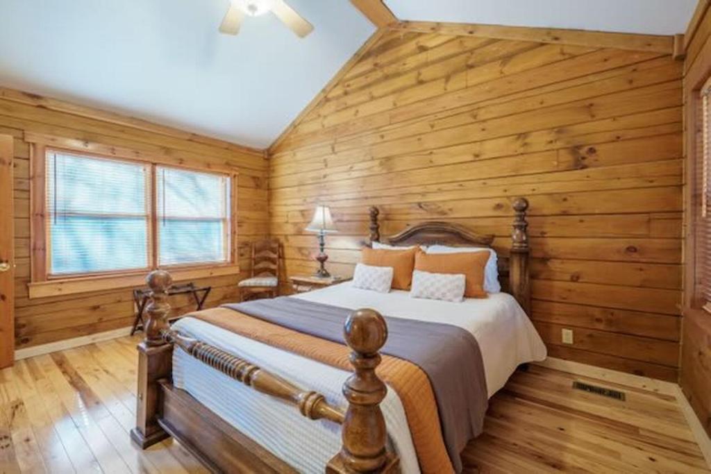 une chambre avec un lit dans un mur en bois dans l'établissement Hidden Gem Cottage, à Blowing Rock