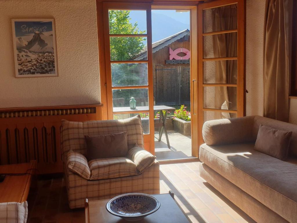 un salon avec un canapé et une chaise dans l'établissement Appartement calme près du lac avec jardin, terrasse, parking et WiFi - FR-1-624-45, à Samoëns