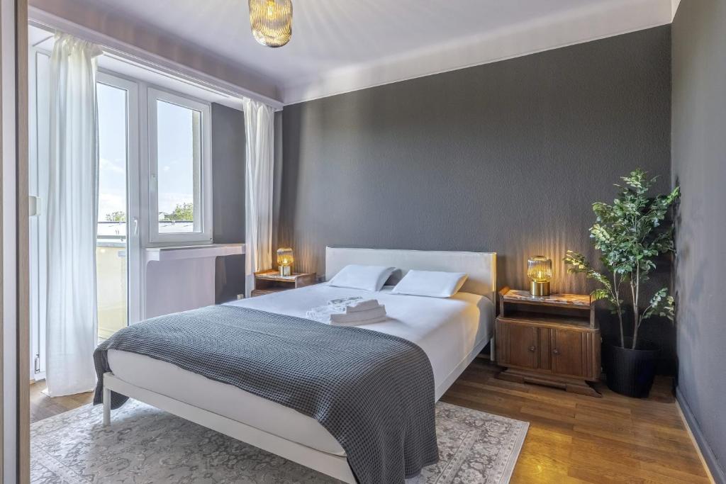 a bedroom with a bed and a large window at Stylish 2BR Apt with Balcony & Views near Center in Luxembourg