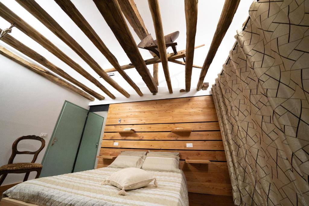 Una habitación con una cama y una pared de madera. en Casa Vacanza Vecchia Mura, en Mura