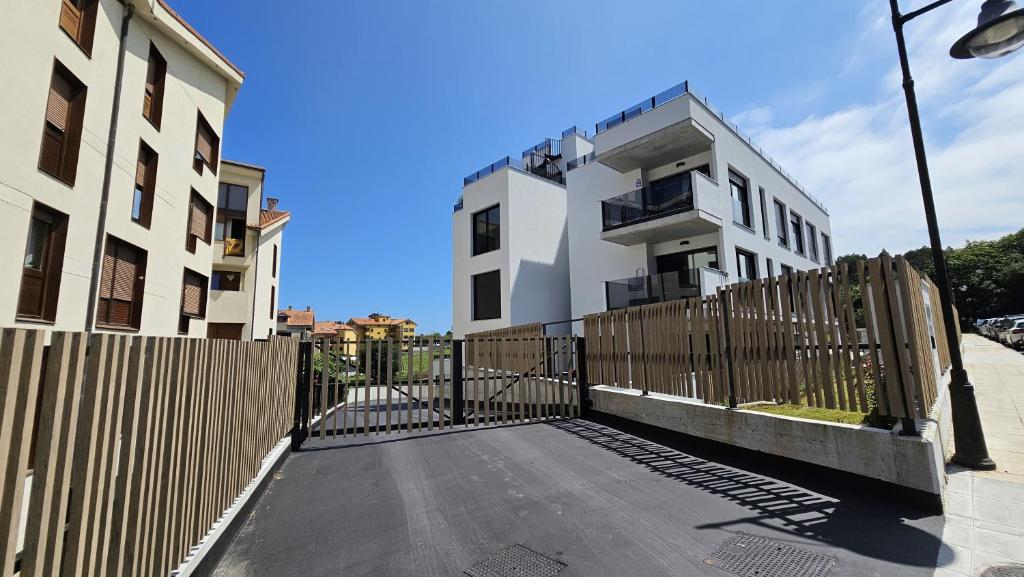 a house with a wooden fence next to a building at Apartamento Mar y Montaña in Barro de Llanes