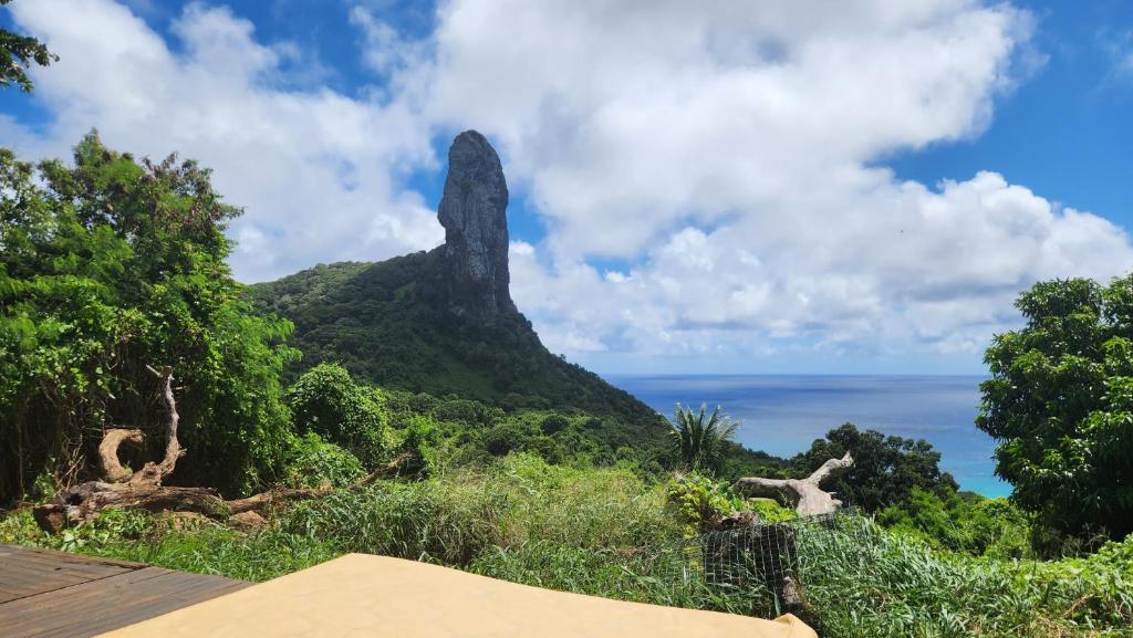 a view of a mountain with the ocean in the background at Casa Beco do Céu in Fernando de Noronha