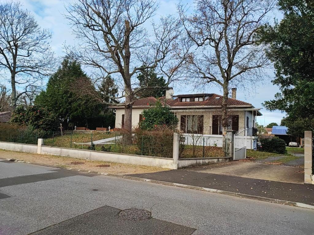 une vieille maison avec une clôture devant elle dans l'établissement Les bananiers 2, à Capbreton