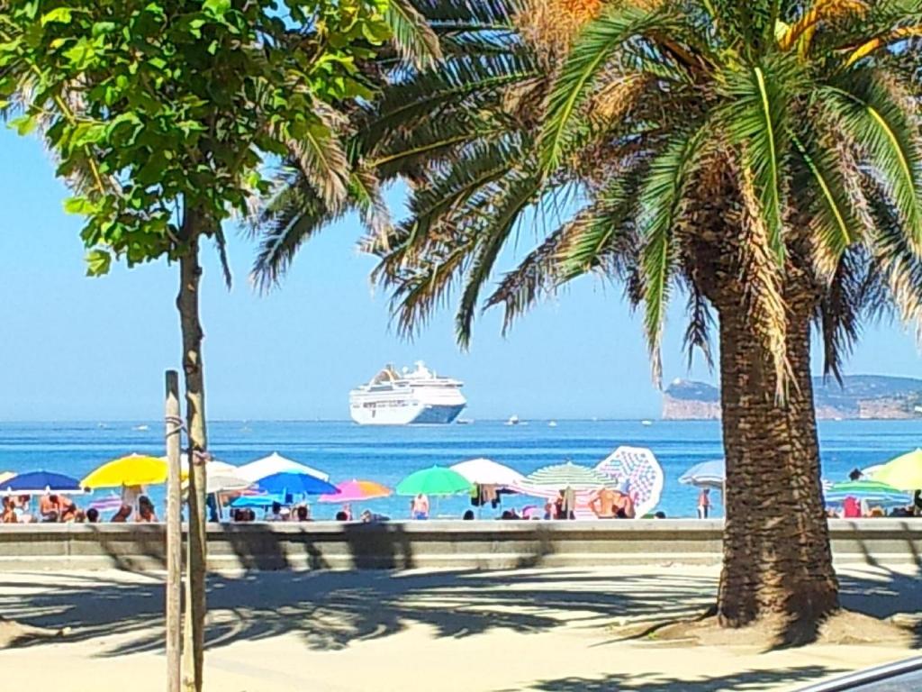 a cruise ship on the beach with palm trees at B&B Jamba self ceck in in Alghero