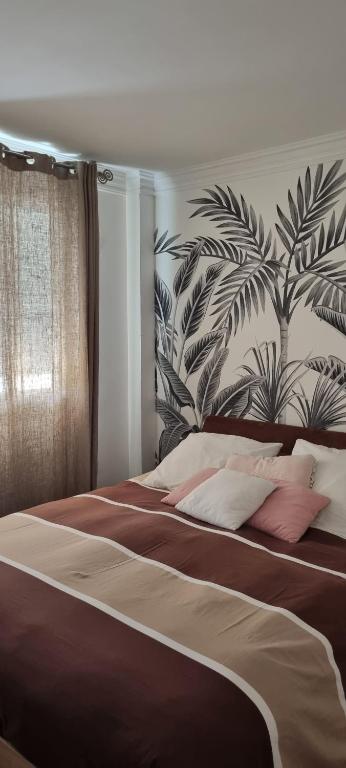 une chambre avec un grand lit avec un tableau au mur dans l'établissement SWEETY HOME - proche PARIS - Parking PRIVE, à Montreuil