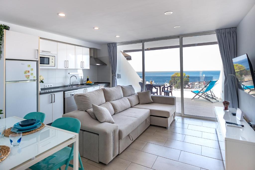 a living room with a couch and a kitchen with a view at Bellavista in Tías