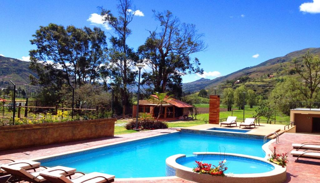 una piscina con tumbonas y un complejo en Arhaná Hosteria & Resort, en Gualaceo