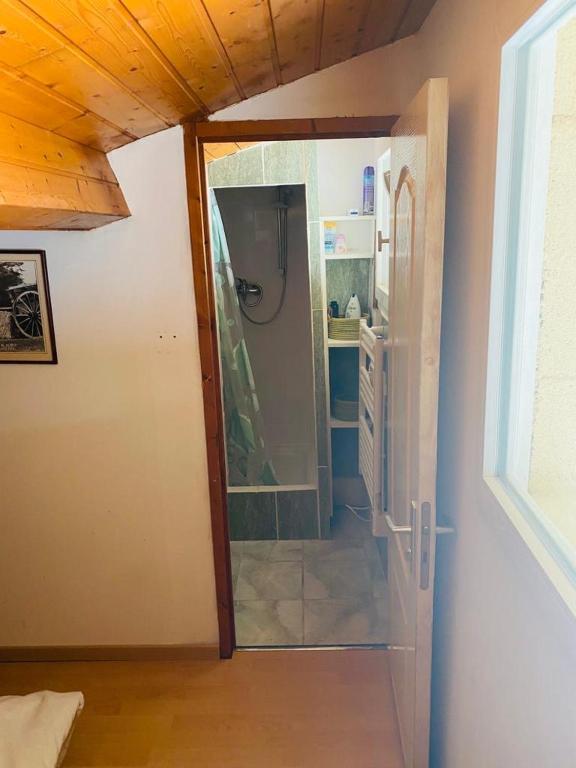 une porte ouverte sur une salle de bains pourvue d'un réfrigérateur. dans l'établissement Chez Philippe, à Saujon
