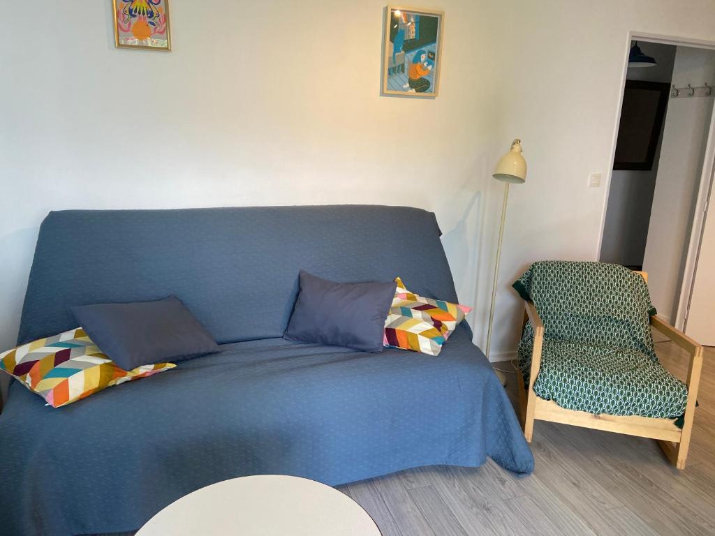 - un lit bleu avec des oreillers et une chaise dans la chambre dans l'établissement 2 pièce calme Strasbourg Cronenbourg 5min centre, à Strasbourg
