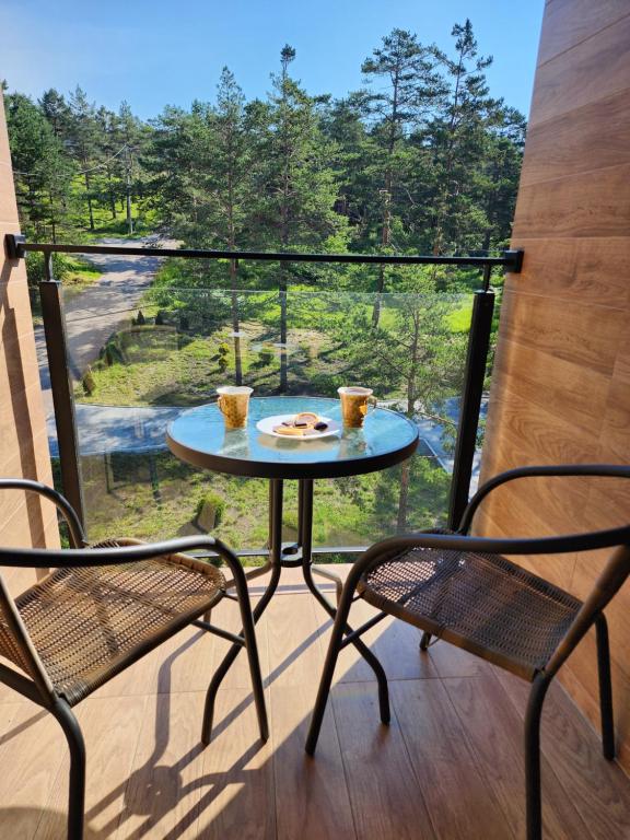 un tavolo e due sedie su un balcone con vista di Apartman Planinski san Divčibare a Divčibare