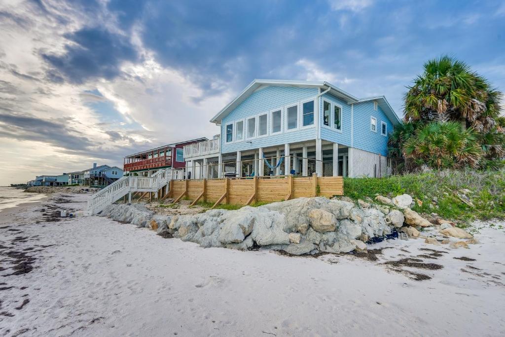 a blue house on the beach next to the ocean at Alligator Point Beachfront Home with Private Hot Tub in Sun N Sand Beaches