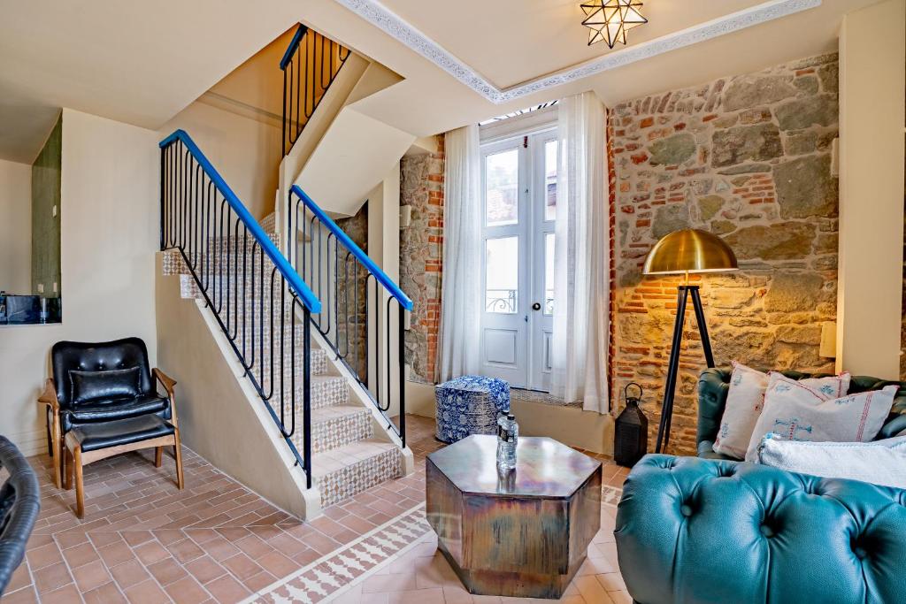 a living room with a blue couch and stairs at AmazINN Places Hotel Boutique Casa Marroqui in Panama City