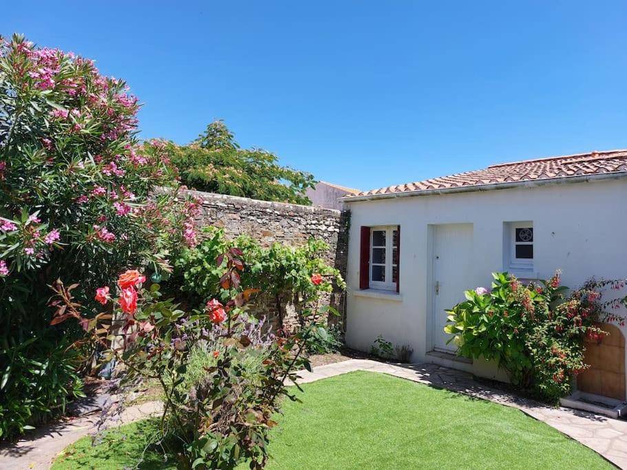 ein Haus mit einem Garten mit rosa Blumen und einem Hof in der Unterkunft Maison de pêcheur - Quartier Croix de Vie in Saint-Gilles-Croix-de-Vie