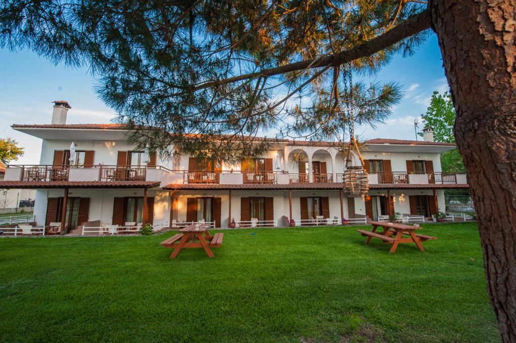 a large building with picnic tables in the yard at Maria Village in Vourvourou
