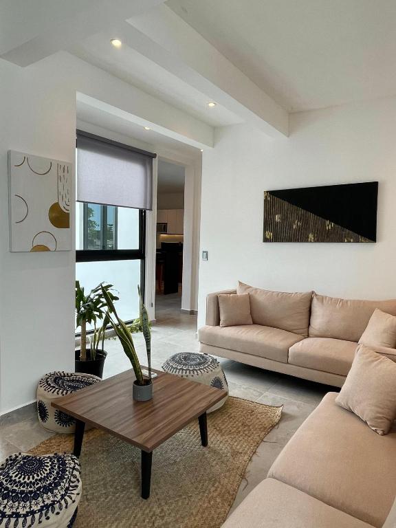 a living room with a couch and a table at DOI 45 Apartment in Playa del Carmen