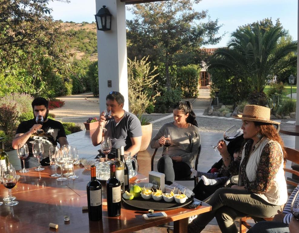 a group of people sitting around a table drinking wine at Hotel Boutique Solaz Bella Vista de Colchagua in Santa Cruz