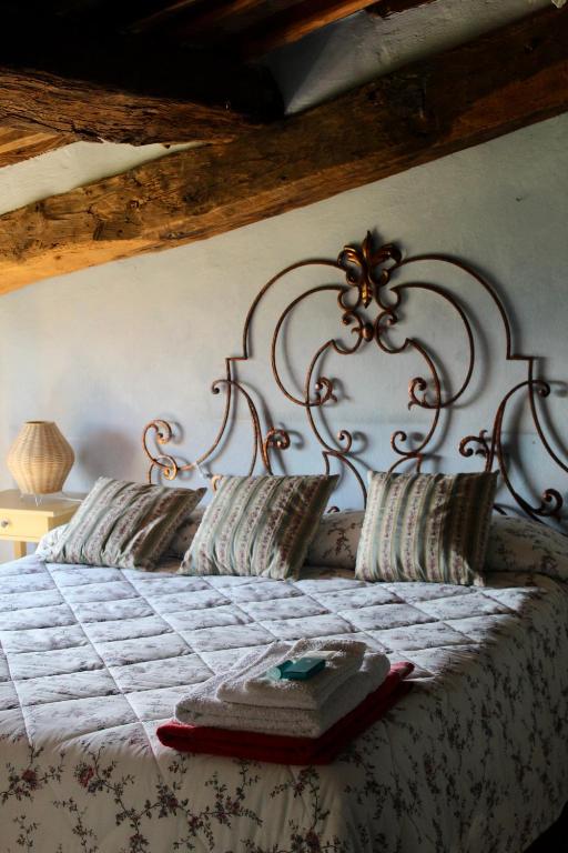a bed with an iron headboard with a book on it at Azienda Agricola Fabbrica Di San Martino in Lucca
