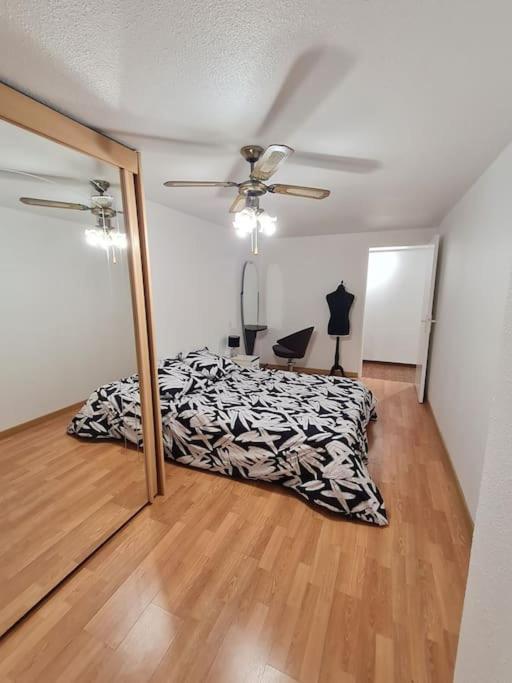 une chambre avec un lit et un ventilateur de plafond dans l'établissement Le BEAU SEJOUR, à Poitiers