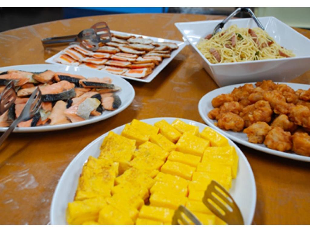 a wooden table with plates of food on it at Sun Hotel Kokubu - Vacation STAY 62468v in Kirishima
