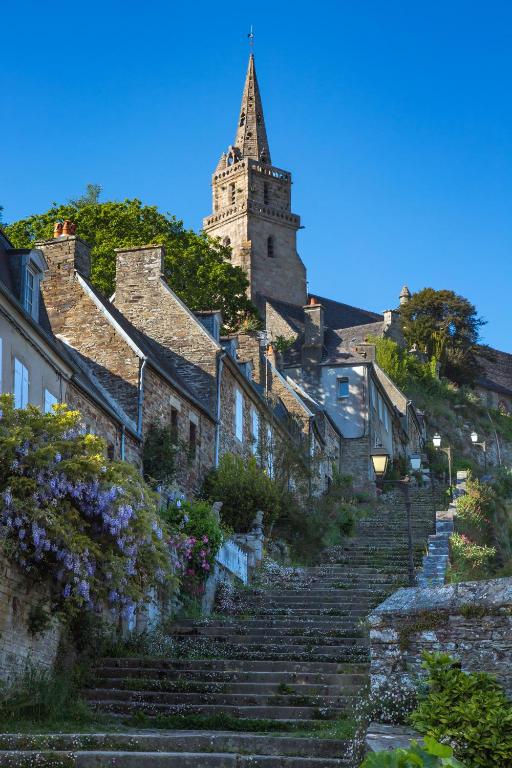 un ensemble d'escaliers menant à un bâtiment avec une tour dans l'établissement Maison de charme dans le site classé de Brélévenez, à Lannion