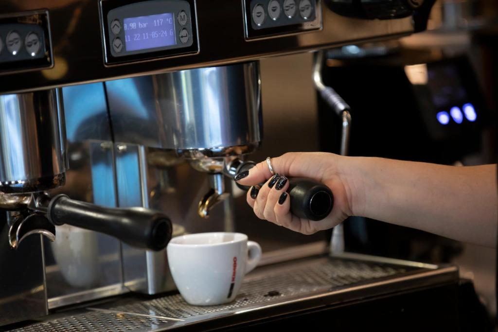 a person is preparing a cup of coffee at Resort Zdrava in Savër