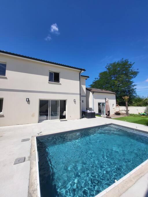 une grande piscine devant une maison dans l'établissement maison avec piscine, à Saint-Médard-en-Jalles