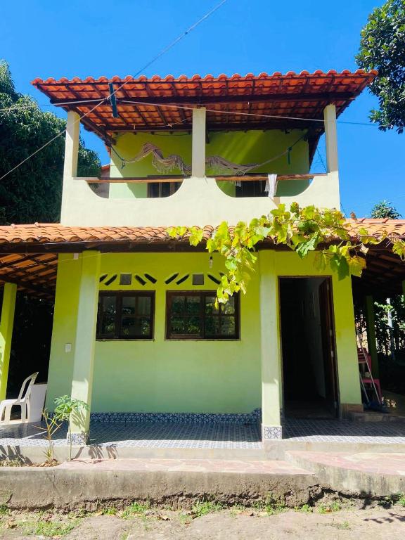 une maison jaune et verte avec un toit rouge dans l'établissement O galpão Casa Flor, à Vale do Capão