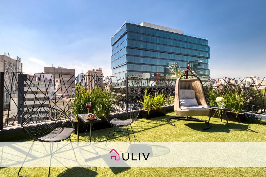 a balcony with two chairs and a swing on a building at ULIV Apartments El Ángel in Mexico City