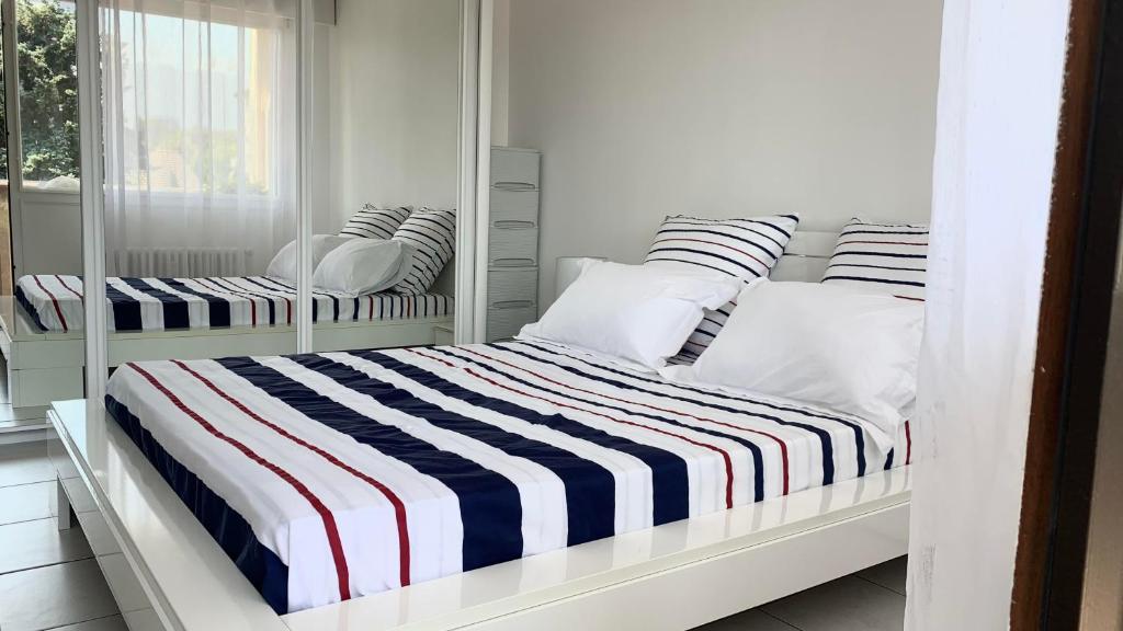 a bedroom with two bunk beds with striped sheets at FLEUR De LYS - PROCHE CENTRE VILLE ET LAC in Thonon-les-Bains