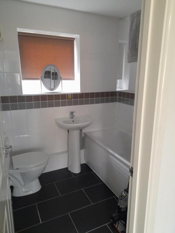 a bathroom with a sink and a toilet and a bath tub at clifftop villa 47 in Corton