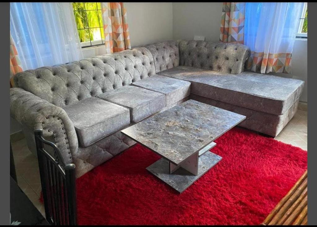 a living room with a couch and a red rug at Little Haven Nyali mombasa in Mombasa