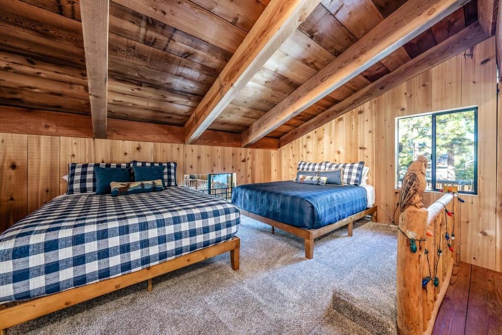 Un dormitorio con dos camas en una cabaña de madera. en Waterfall Lodge Yellowstone Vibes Ac Space, en Shaver Lake