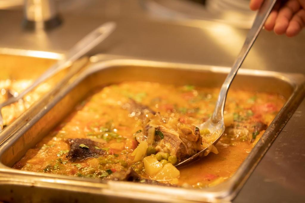 a person holding a fork in a pan of food at Resort Zdrava in Savër
