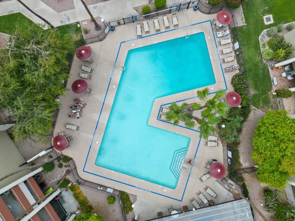 スコッツデールにあるCozy 2br Condo W Pool Near Old Townのパラソル付きのスイミングプールのオーバーヘッドビュー