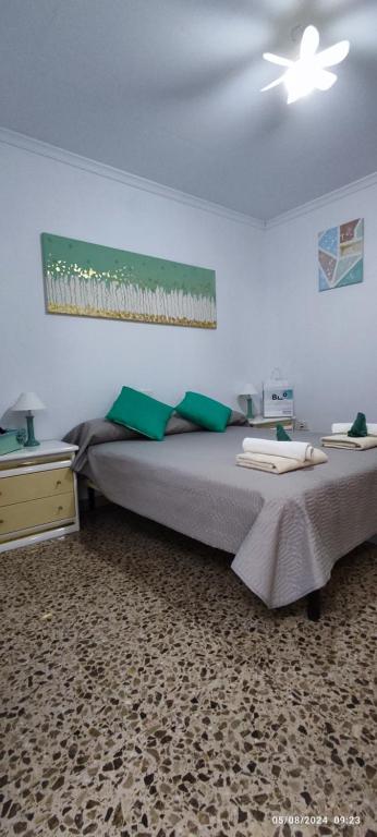 a bedroom with a large bed with green pillows at HolaMar in Benicarló