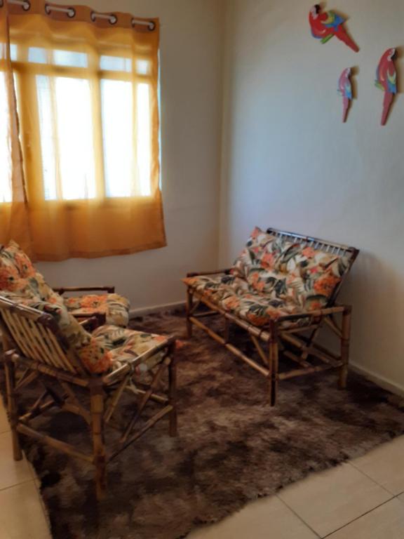 a living room with two chairs and a window at Casa a 4 minutos do santuário in Aparecida