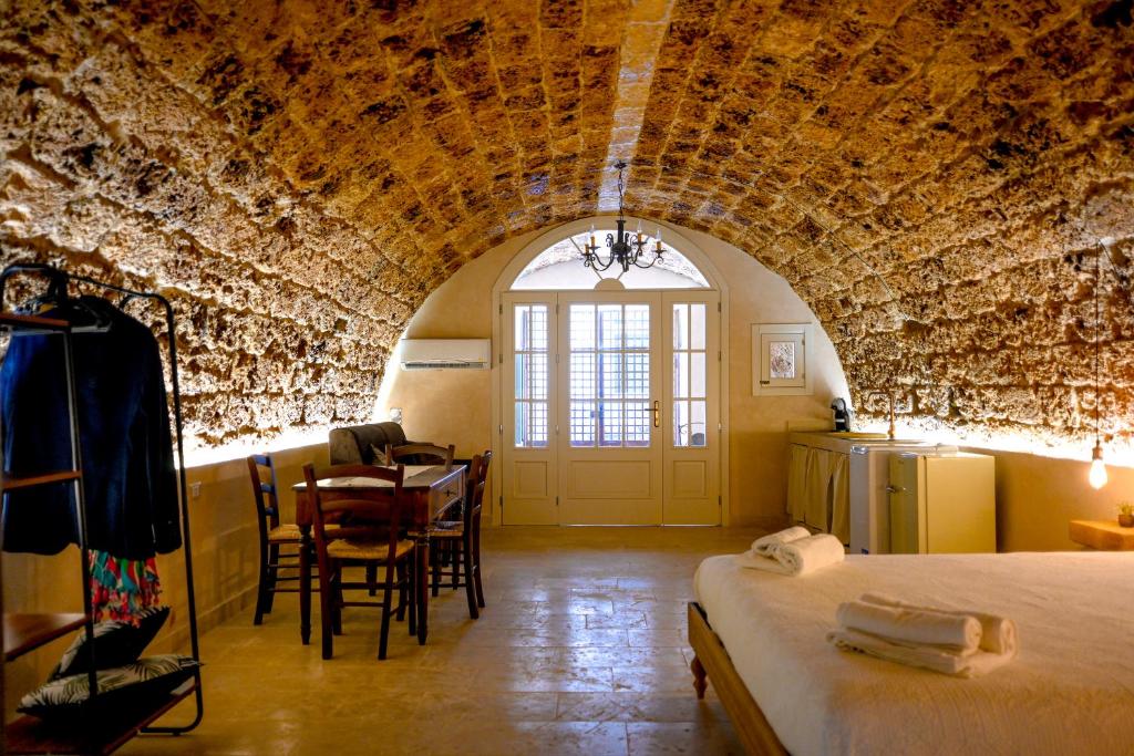 ノートにあるLA GROTTA, luxury suite & Spaのベッドとテーブルと椅子のある部屋