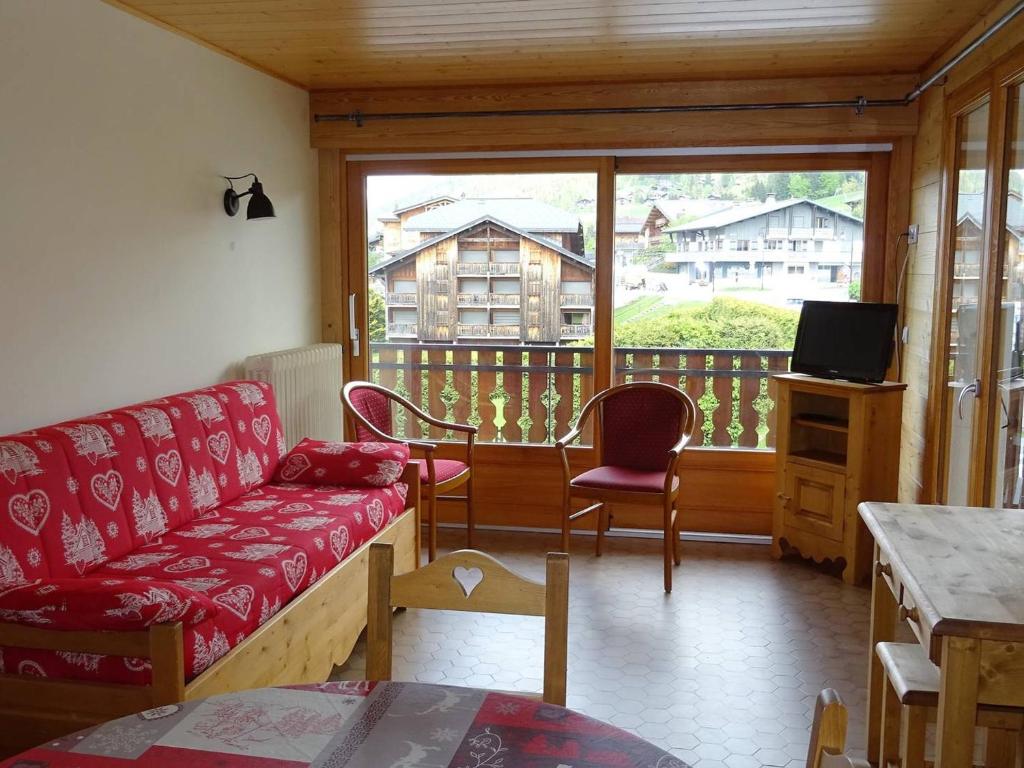 un salon avec un canapé et une grande fenêtre dans l'établissement Appartement 3 pièces aux Gets - 6 pers, WiFi, garage, balcon, proche commerces et ESF - FR-1-802-5, aux Gets