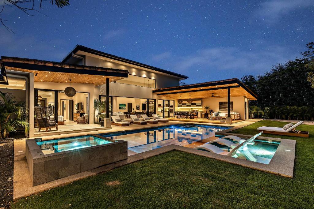 a house with a swimming pool in the yard at Casa Ola Aloha in Playa Avellana