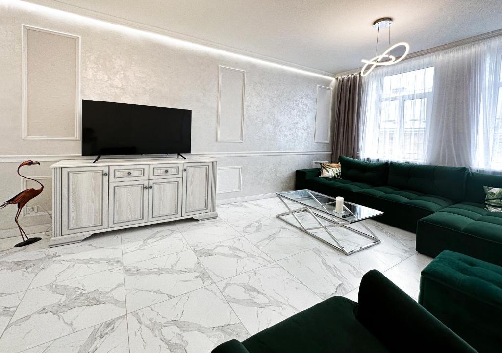 a living room with a couch and a flat screen tv at Tamanska Luxury Apartments in Lviv