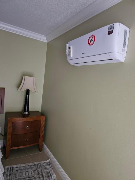 Una habitación de hotel con un aire acondicionado colgado de una pared. en Pretige Studio, en Orlando