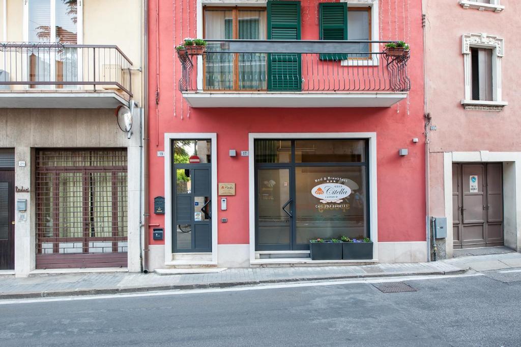 een rood gebouw met een deur en een raam bij Casa Citella in Bussolengo