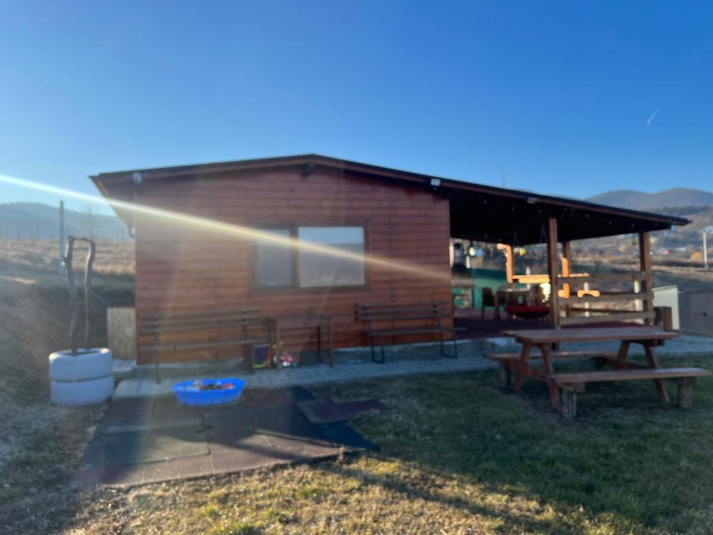 a log cabin with a picnic table and a grill at Cabana Cetate Panorama Deva in Deva