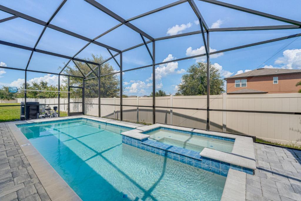 a large swimming pool with a glass roof at Relax, Play, Swim Luxe Haines City Home with Lanai! in Haines City