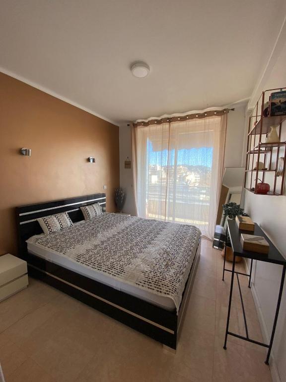 une chambre avec un grand lit et une fenêtre dans l'établissement 3 Pièces Vue mer & Iles de Lérins, à Cannes