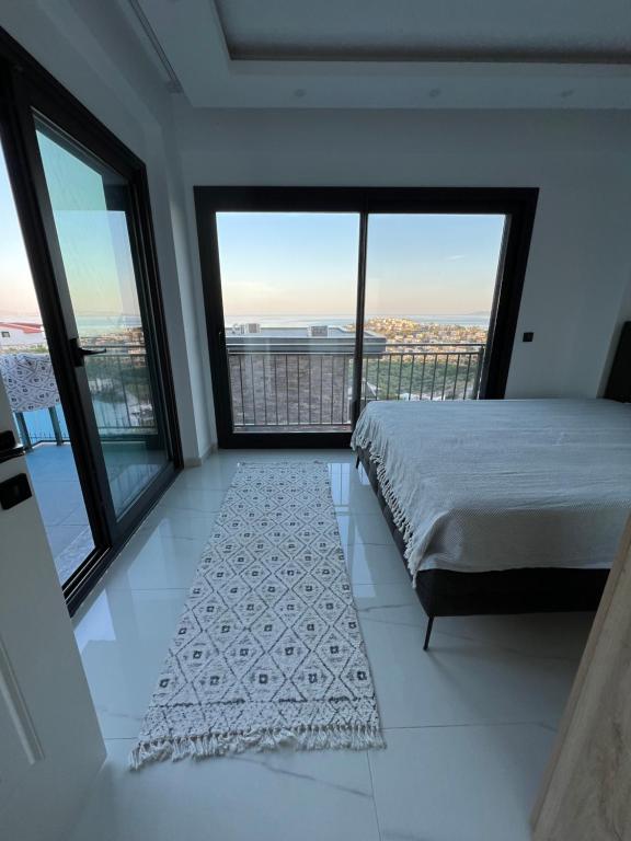 a bedroom with a bed and large windows at Villa Yakışıklı Bodrum vue mer avec piscine privée in Milas