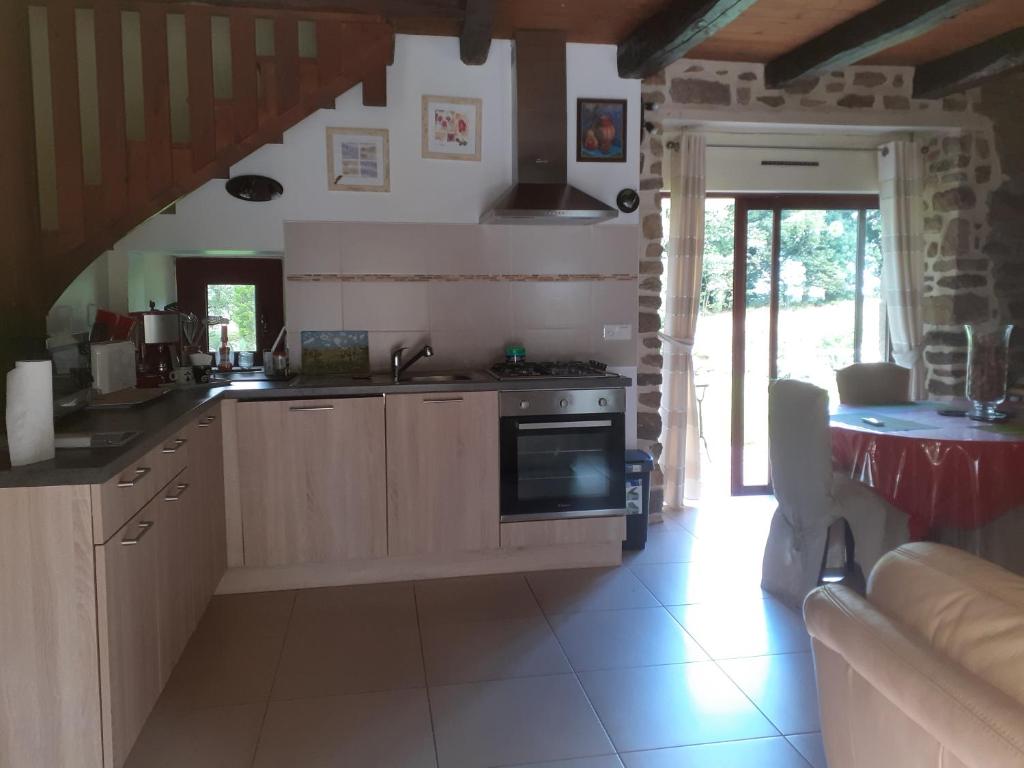 une cuisine avec un évier et une cuisinière dans l'établissement refuge de la chouette, à Saint-Gilles-Pligeaux