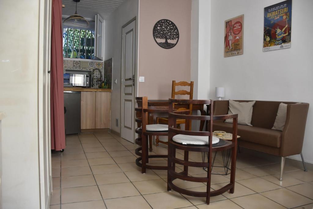 une cuisine et un salon avec une table et des chaises dans l'établissement Escapade Paisible, Saint-Eugène, à Marseille