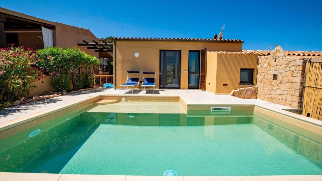 a swimming pool in front of a house at Villa Vincent in Costa Paradiso