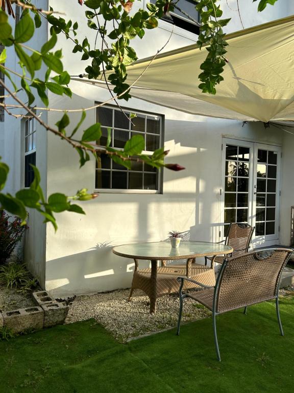 a patio with a table and chairs in front of a building at Scarlett Studios 3-US Embassy 7 mins drive- Lloyd Erskine Sandiford Centre & Ross university 5 mins drive-Only a 1 night reservation includes airport and embassy round trip in Bridgetown